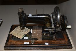 A late 19th / early 20th century Singer style sewing machine, supported on an ebonised wooden