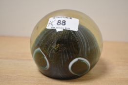 A John Ditchfield art glass paperweight, of spherical form with integral iridescent swirl design,