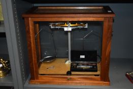 A handsome early 20th century Towers Widnes scientific weighing scale, housed in a wooden display