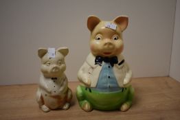 A pair of mid-century ceramic piggy banks, modelled as comical father pig and baby pig, hand