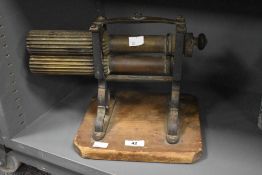 A late 19th / early 20th century table top crampon machine, supported on a square pine base, h24cm.