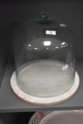 A large hand blown lime green glass domed cake bell on white marble base, H34.