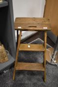A late 19th /early 20th century pine two tier folding step ladder, having iron fixtures, h60cm.