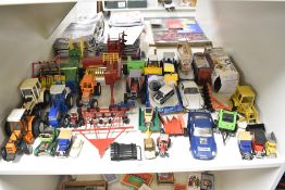 A shelf of playworn die-casts and plastic Farm Toys including Britains, Ertl etc