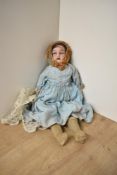 An early 20th century GOSS bisque headed doll having fixed open eyes and mouth, cloth stitched body