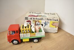 A Tomy tin plate and battery operated Ol McDonald's Farm Truck, appears complete in original box, no
