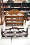 Eighteen Danbury Mint Pewter Jaguar Cars, 1935 SS1 Saloon through to 1992 XJ220 all on two wooden