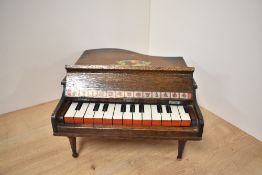 A wooden framed toy Baby Grand Piano with 13 keys