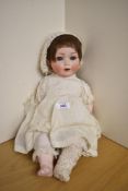 A early 20th century Simon Halbig bisque headed Doll having sleep blue eyes, open mouth with two