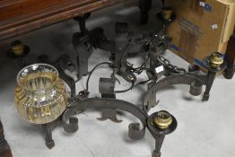 A cast iron electric ceiling light fitting in the medieval chandelier style, with glass shades