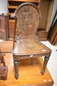A 19th Century oak hall chair having shield back with turned legs