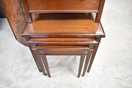 A reproduction mahogany nest of three tables