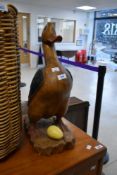 A wooden ornament modelled as duck or goose with egg, height approx. 51cm