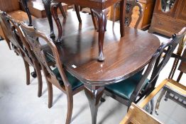 An early 20th Century draw leaf dining table having cabriole legs and ball and claw feet