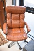 A vintage style brown leather office armchair