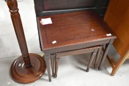A reproduction mahogany nest of three tables