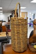 A tall wicker umbrella or stick stand style basket