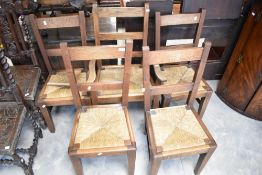 A set of five (four plus one) traditionally made oak rail back chairs having rush seats