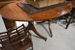 An early 20th Century Regency revival oval dining table, with extending leaf
