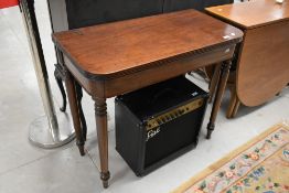 A 19th Century mahogany fold over tea table on turned legs