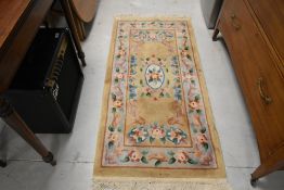 A modern Chinese fireside rug, having ochre ground, approx. 150 x 70cm