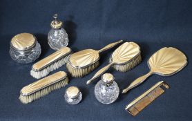 A George V golden guilloche enamel and silver mounted vanity set, comprising two hair brushes, two