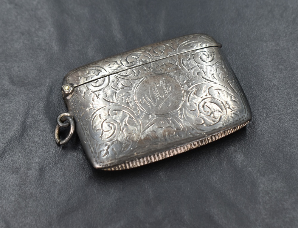 A George V silver vesta case, of rectangular form having engraved scroll decoration and central
