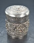 A Eastern white metal trinket pot, having embossed scenes of figures in traditional clothing