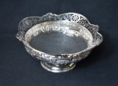 An impressive Edwardian silver pedestal fruit bowl, having a flared lobed rim with pierced scroll