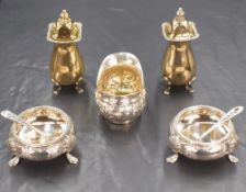 A pair of George VI silver gilt pepperettes, of bulbous form having gadrooned and shell decoration