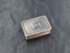 A William IV silver vinaigrette, of hinged rectangular form, having a raised scroll border, engine