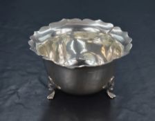 A late Edwardian silver sugar bowl, having a flared lobed rim, raised on three cabriole style