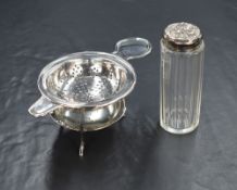 A George V silver tea strainer, of traditional circular form having a plain moulded rim, with a