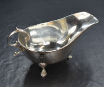 A George V silver sauce boat, having ribbon and thread decoration to rim, narrow spout opposed by