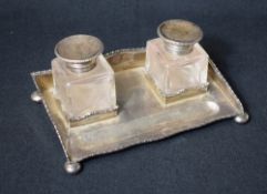 A George V silver inkwell stand with silver mounted cut glass inkwells, of rectangular form having a