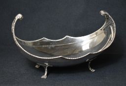 An impressive George V silver bowl, of long boat form having an egg and dart rim with scroll