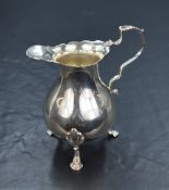 An Edwardian silver cream jug, having a lobed rim with a generous flat spout, opposed by a