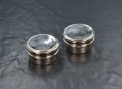 A matching pair of George V silver pill boxes, of circular form having decorative moulding to the