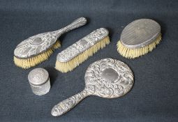 An Elizabeth II silver mounted hand mirror, having embossed scroll work, along with a silver mounted