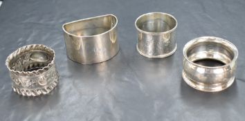 A group of four silver napkin rings, of various size and design including embossed floral work,