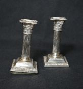 A pair of Victorian silver Corinthian column candlesticks, having concave square detachable
