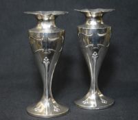 A pair of Edwardian silver vases, of oval fluted form having a lobed floral motif rim with