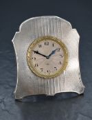 An early 20th century white metal (presumed silver) desk clock, having engine turned decoration to