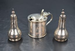 A cased Edwardian silver condiment set, comprising a mustard having a blue glass liner and two