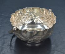A Victorian silver sugar bowl, of circular form having a crimped rim and embossed decoration to