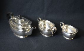 A George V silver three piece silver tea set, comprising a tea pot, sugar and cream, of bulbous oval
