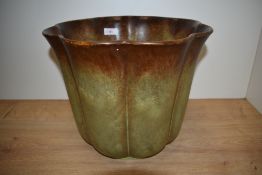 A 20th Century German lobed jardiniere, covered in a dripped green/brown glaze with maker's mark