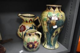 A Medina pottery baluster ceramic vase, hand-painted with a floral pattern on a glazed ground,