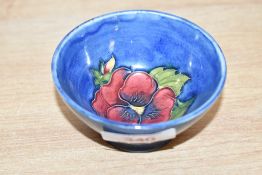 A small attractive Moorcroft pottery bowl, decorated with poppy on a blue glaze ground, pattern No.