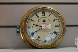 An early 20th century mechanical brass ships bulkhead clock, having Roman numerals, manufactured
